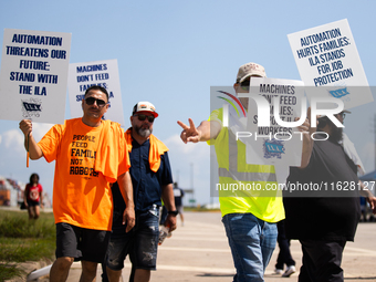 Dockworkers and their supporters hold signs during a strike outside the Bayport Container Terminal in Seabrook, Texas, on October 1, 2024. (