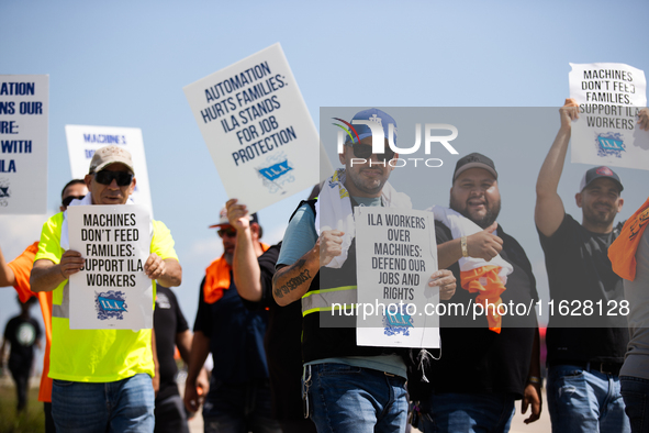 Dockworkers and their supporters hold signs during a strike outside the Bayport Container Terminal in Seabrook, Texas, on October 1, 2024. 