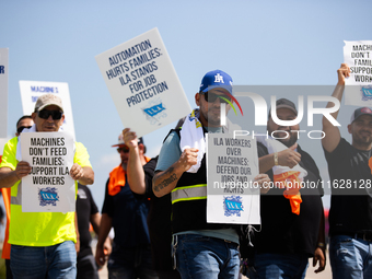 Dockworkers and their supporters hold signs during a strike outside the Bayport Container Terminal in Seabrook, Texas, on October 1, 2024. (