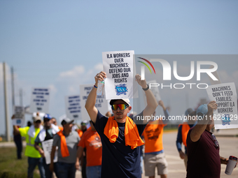 Dockworkers and their supporters hold signs during a strike outside the Bayport Container Terminal in Seabrook, Texas, on October 1, 2024. (