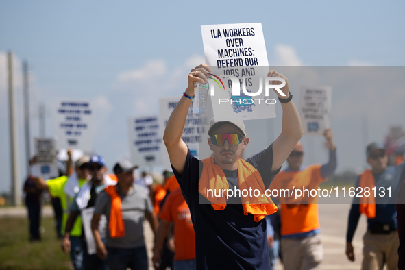 Dockworkers and their supporters hold signs during a strike outside the Bayport Container Terminal in Seabrook, Texas, on October 1, 2024. 