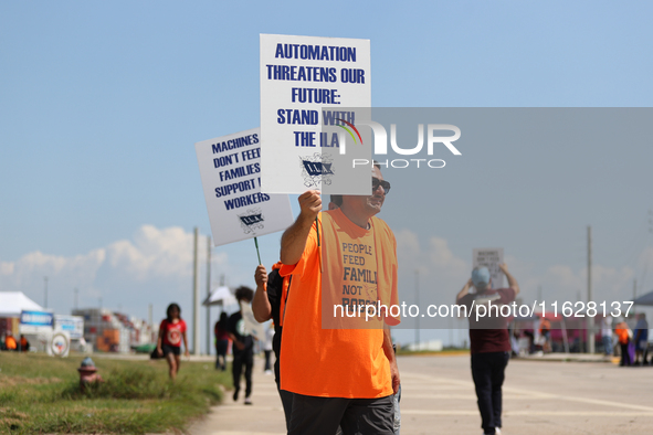 Dockworkers and their supporters hold signs during a strike outside the Bayport Container Terminal in Seabrook, Texas, on October 1, 2024. 