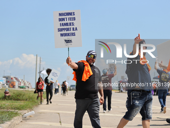 Dockworkers and their supporters hold signs during a strike outside the Bayport Container Terminal in Seabrook, Texas, on October 1, 2024. (