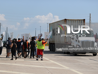 A passing semi-truck honks in a show of support during a dockworker strike outside the Bayport Container Terminal in Seabrook, Texas, on Oct...