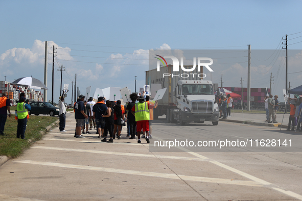 A passing semi-truck honks in a show of support during a dockworker strike outside the Bayport Container Terminal in Seabrook, Texas, on Oct...