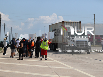 A passing semi-truck honks in a show of support during a dockworker strike outside the Bayport Container Terminal in Seabrook, Texas, on Oct...