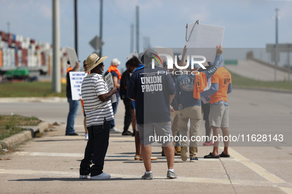 Dockworkers and their supporters hold signs during a strike outside the Bayport Container Terminal in Seabrook, Texas, on October 1, 2024. 