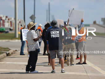 Dockworkers and their supporters hold signs during a strike outside the Bayport Container Terminal in Seabrook, Texas, on October 1, 2024. (