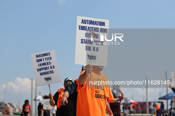 Dockworkers and their supporters hold signs during a strike outside the Bayport Container Terminal in Seabrook, Texas, on October 1, 2024. 