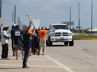 A passing driver holds up his fist in solidarity with a group of striking dockworkers outside the Bayport Container Terminal in Seabrook, Te...