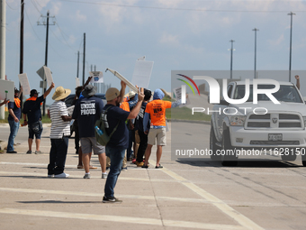 A passing driver holds up his fist in solidarity with a group of striking dockworkers outside the Bayport Container Terminal in Seabrook, Te...