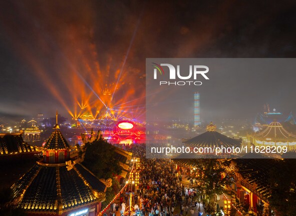 Visitors watch a light show at the West Tour Park in Huai'an City, China, on October 1, 2024. 