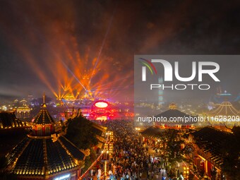 Visitors watch a light show at the West Tour Park in Huai'an City, China, on October 1, 2024. (