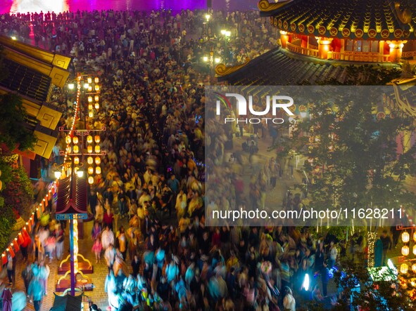 Visitors watch a light show at the West Tour Park in Huai'an City, China, on October 1, 2024. 