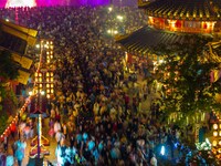 Visitors watch a light show at the West Tour Park in Huai'an City, China, on October 1, 2024. (