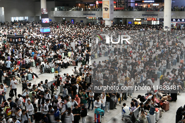 A large number of passengers wait in the waiting room of Nanchang Railway Station in Nanchang, China, on October 1, 2024. 