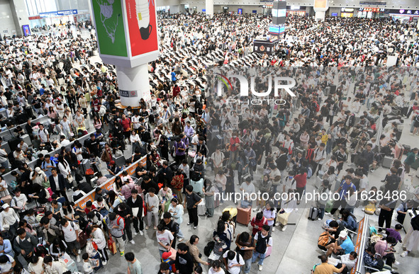 A large number of passengers wait in the waiting room of Nanchang Railway Station in Nanchang, China, on October 1, 2024. 