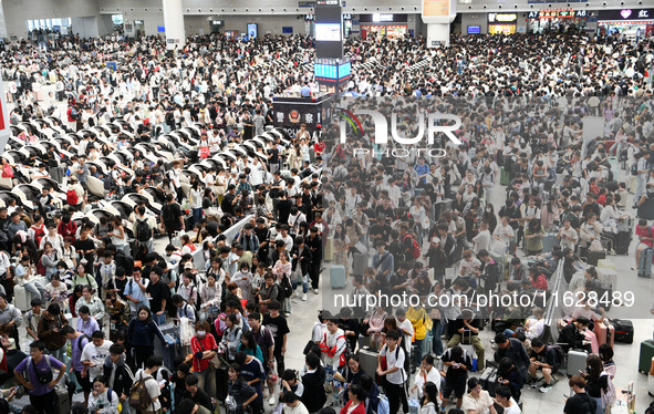 A large number of passengers wait in the waiting room of Nanchang Railway Station in Nanchang, China, on October 1, 2024. 