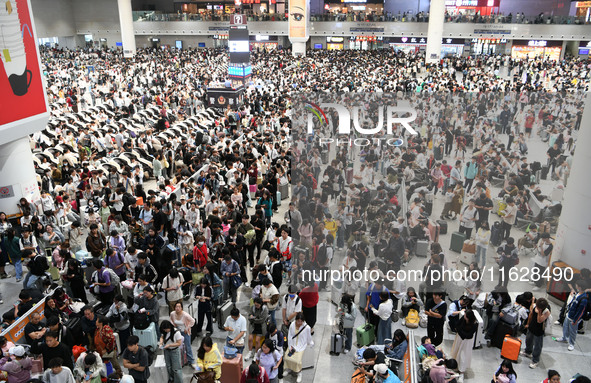 A large number of passengers wait in the waiting room of Nanchang Railway Station in Nanchang, China, on October 1, 2024. 