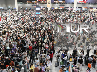 A large number of passengers wait in the waiting room of Nanchang Railway Station in Nanchang, China, on October 1, 2024. (