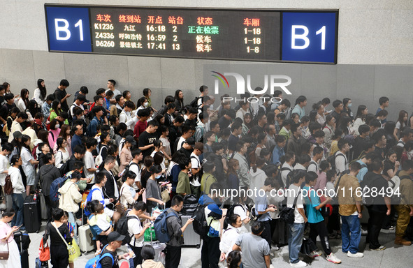 Passengers check their tickets at the waiting room of Nanchang Railway Station in Nanchang, China, on October 1, 2024. 