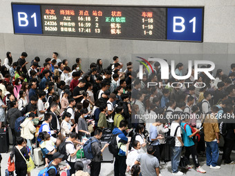 Passengers check their tickets at the waiting room of Nanchang Railway Station in Nanchang, China, on October 1, 2024. (