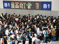 Passengers check their tickets at the waiting room of Nanchang Railway Station in Nanchang, China, on October 1, 2024. (