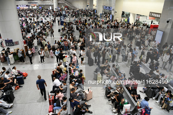 A large number of passengers wait in the waiting room of Nanchang Railway Station in Nanchang, China, on October 1, 2024. 