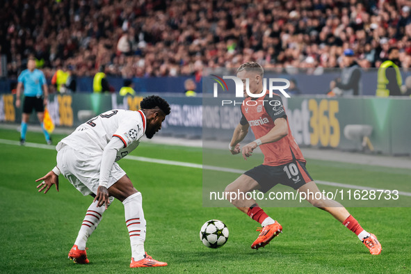 Florian Wirtz of Bayer 04 Leverkusen and Emerson of AC Milan are in action during the UEFA Champions League 2024/25 League Phase MD2 match b...