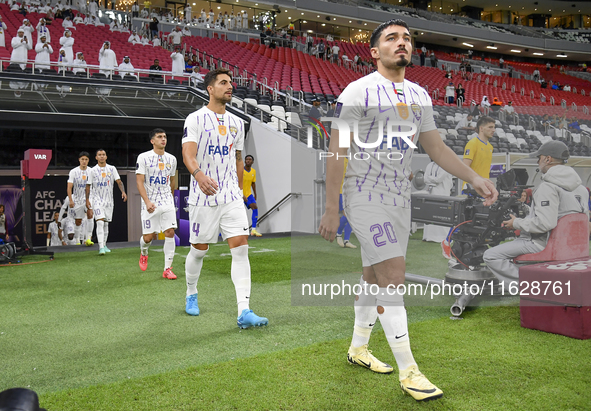 Players of Al Ain FC and Al-Gharafa SC arrive on the pitch before the AFC Champions League elite west football match between Qatar's Al Ghar...