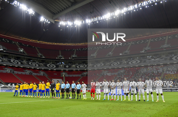 Players of Al Ain FC (R) and Al-Gharafa SC (L) teams line up before the AFC Champions League elite west football match between Qatar's Al Gh...