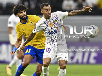 Ferjani Sassi (L) of Al Gharafa SC battles for the ball with Kaku of Al Ain FC during the AFC Champions League elite west football match bet...