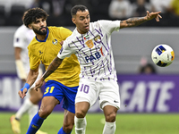 Ferjani Sassi (L) of Al Gharafa SC battles for the ball with Kaku of Al Ain FC during the AFC Champions League elite west football match bet...