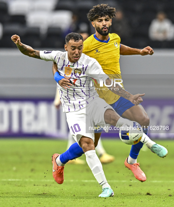 Ferjani Sassi (R) of Al Gharafa SC battles for the ball with Kaku of Al Ain FC during the AFC Champions League elite west football match bet...