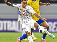 Ferjani Sassi (R) of Al Gharafa SC battles for the ball with Kaku of Al Ain FC during the AFC Champions League elite west football match bet...