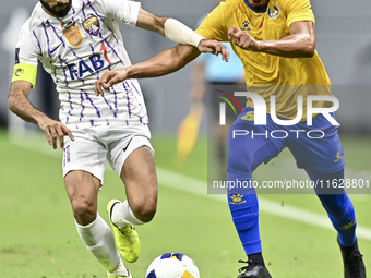 Yacine Brahimi (R) of Al Gharafa SC and Bandar Al Ahbabi of Al Ain FC are in action during the AFC Champions League elite west football matc...