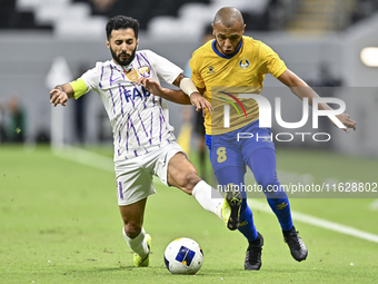 Yacine Brahimi (R) of Al Gharafa SC and Bandar Al Ahbabi of Al Ain FC are in action during the AFC Champions League elite west football matc...