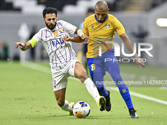 Yacine Brahimi (R) of Al Gharafa SC and Bandar Al Ahbabi of Al Ain FC are in action during the AFC Champions League elite west football matc...