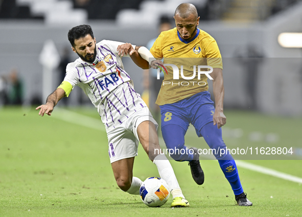 Yacine Brahimi (R) of Al Gharafa SC and Bandar Al Ahbabi of Al Ain FC are in action during the AFC Champions League elite west football matc...