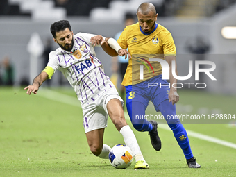 Yacine Brahimi (R) of Al Gharafa SC and Bandar Al Ahbabi of Al Ain FC are in action during the AFC Champions League elite west football matc...