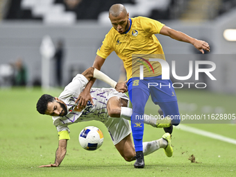 Yacine Brahimi (R) of Al Gharafa SC and Bandar Al Ahbabi of Al Ain FC are in action during the AFC Champions League elite west football matc...