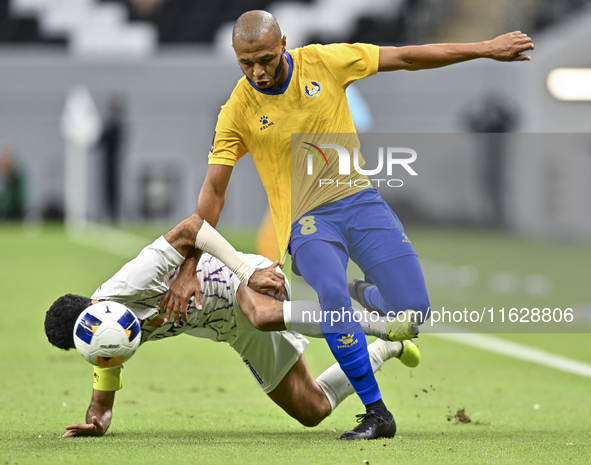 Yacine Brahimi (R) of Al Gharafa SC and Bandar Al Ahbabi of Al Ain FC are in action during the AFC Champions League elite west football matc...