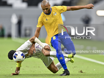 Yacine Brahimi (R) of Al Gharafa SC and Bandar Al Ahbabi of Al Ain FC are in action during the AFC Champions League elite west football matc...