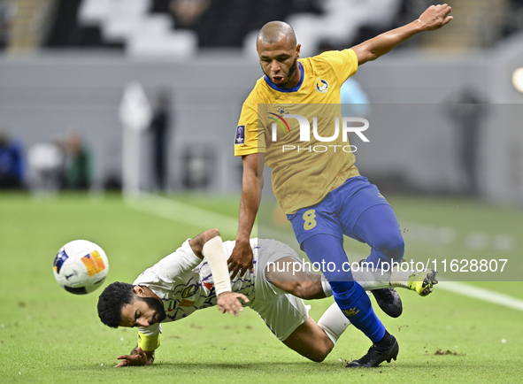 Yacine Brahimi (R) of Al Gharafa SC and Bandar Al Ahbabi of Al Ain FC are in action during the AFC Champions League elite west football matc...