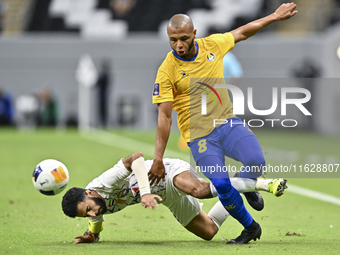 Yacine Brahimi (R) of Al Gharafa SC and Bandar Al Ahbabi of Al Ain FC are in action during the AFC Champions League elite west football matc...