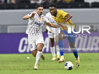 Saifeldeen Hassan Fadlalla (R) of Al Gharafa SC battles for the ball with Kaku of Al Ain FC during the AFC Champions League elite west footb...