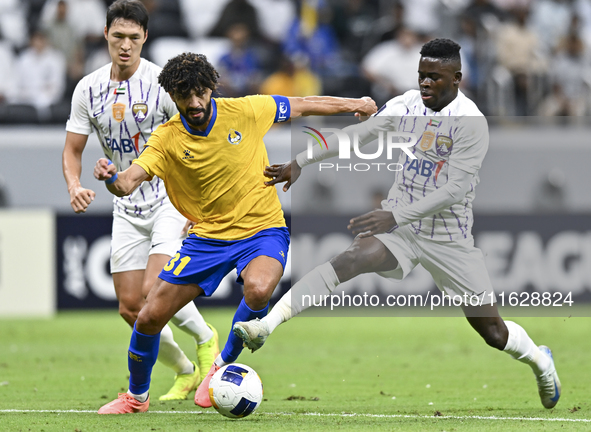 Ferjani Sassi (L) of Al Gharafa SC battles for the ball with Abdoul Karim Traore of Al Ain FC during the AFC Champions League elite west foo...