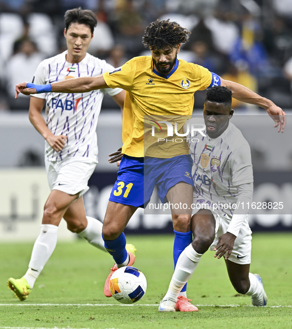 Ferjani Sassi (L) of Al Gharafa SC battles for the ball with Abdoul Karim Traore of Al Ain FC during the AFC Champions League elite west foo...