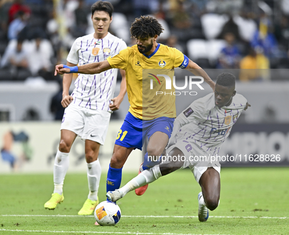 Ferjani Sassi (L) of Al Gharafa SC battles for the ball with Abdoul Karim Traore of Al Ain FC during the AFC Champions League elite west foo...