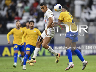 Abdallah Sirelkhatim (R) of Al Gharafa SC battles for the ball with Soufiane Rahimi of Al Ain FC during the AFC Champions League elite west...